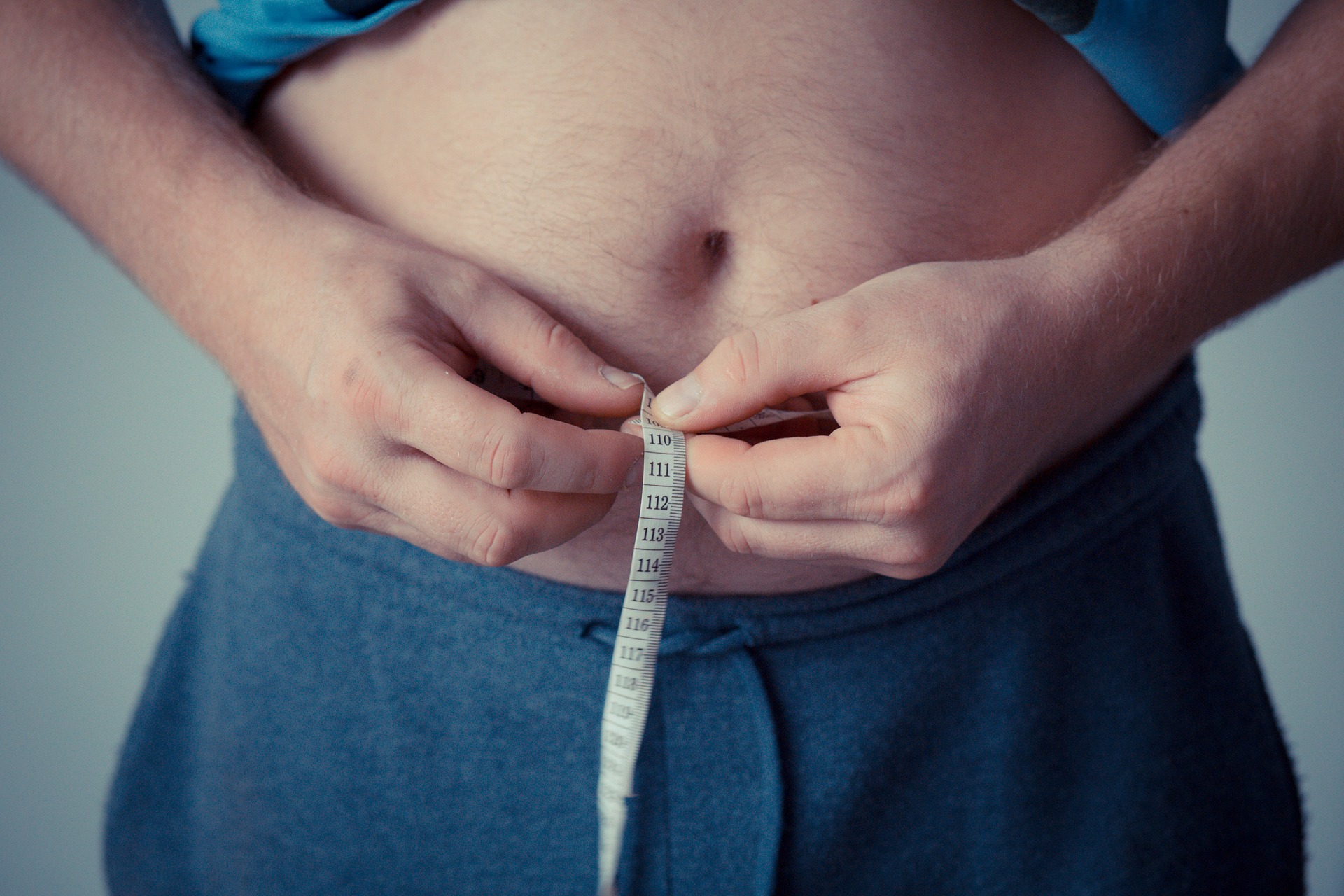 お腹周りの脂肪が気になり、腹筋運動でダイエットする男性